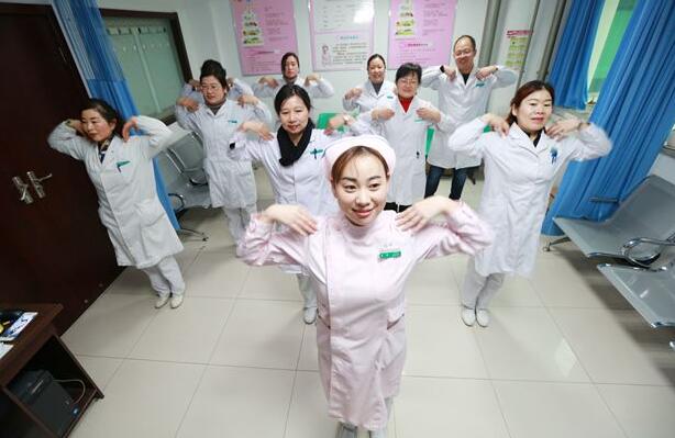 湖北省襄阳市中医医院妇产科门诊候诊区，医护人员做起颈椎保健操